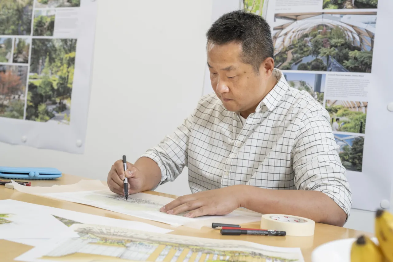 Gillespies' concept artist sketching at a table