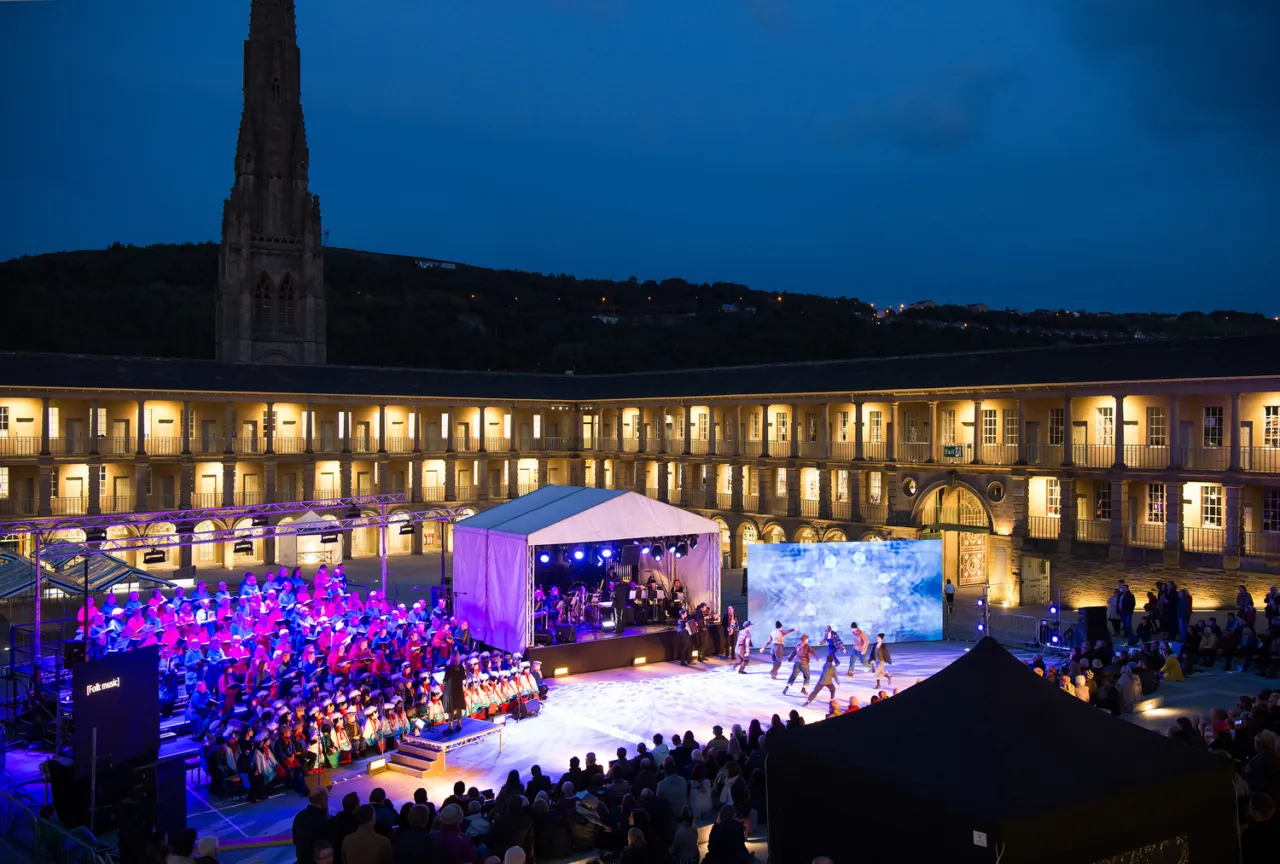 Piece Hall at night with a stage performance