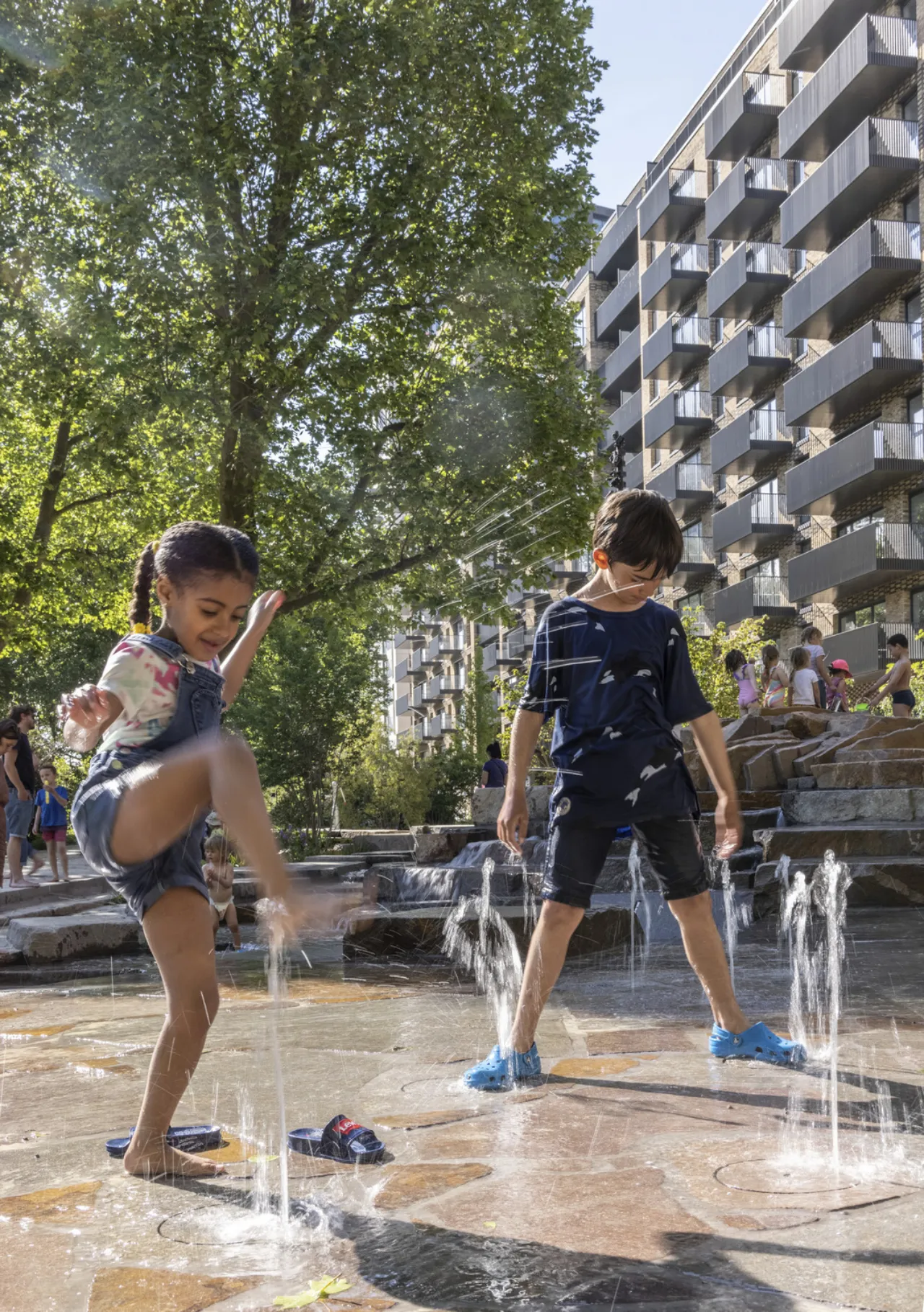 Children playing in the Elephant Springs water feature at Elephant Park by Gillespies