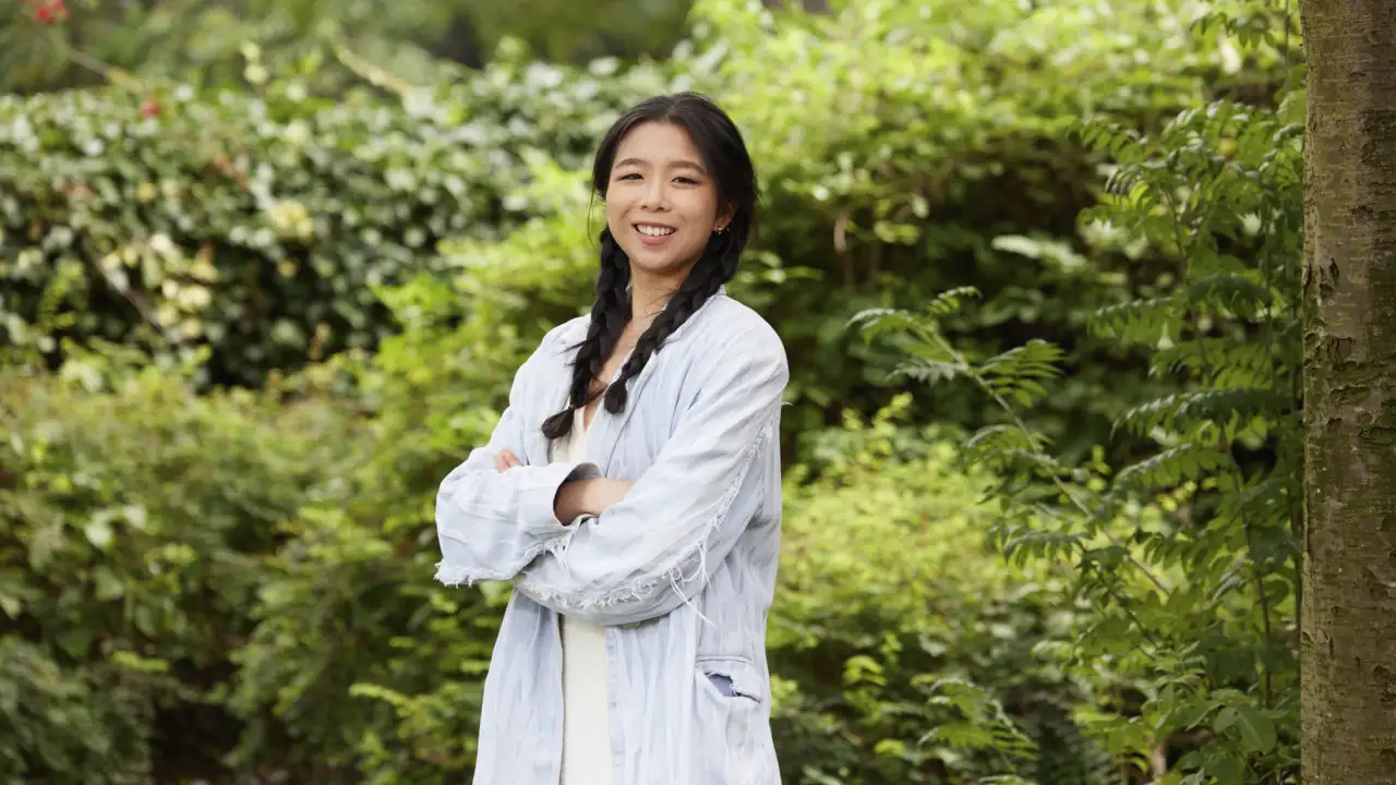 Yingming Hu, landscape architect smiling in a parkland setting in Leeds