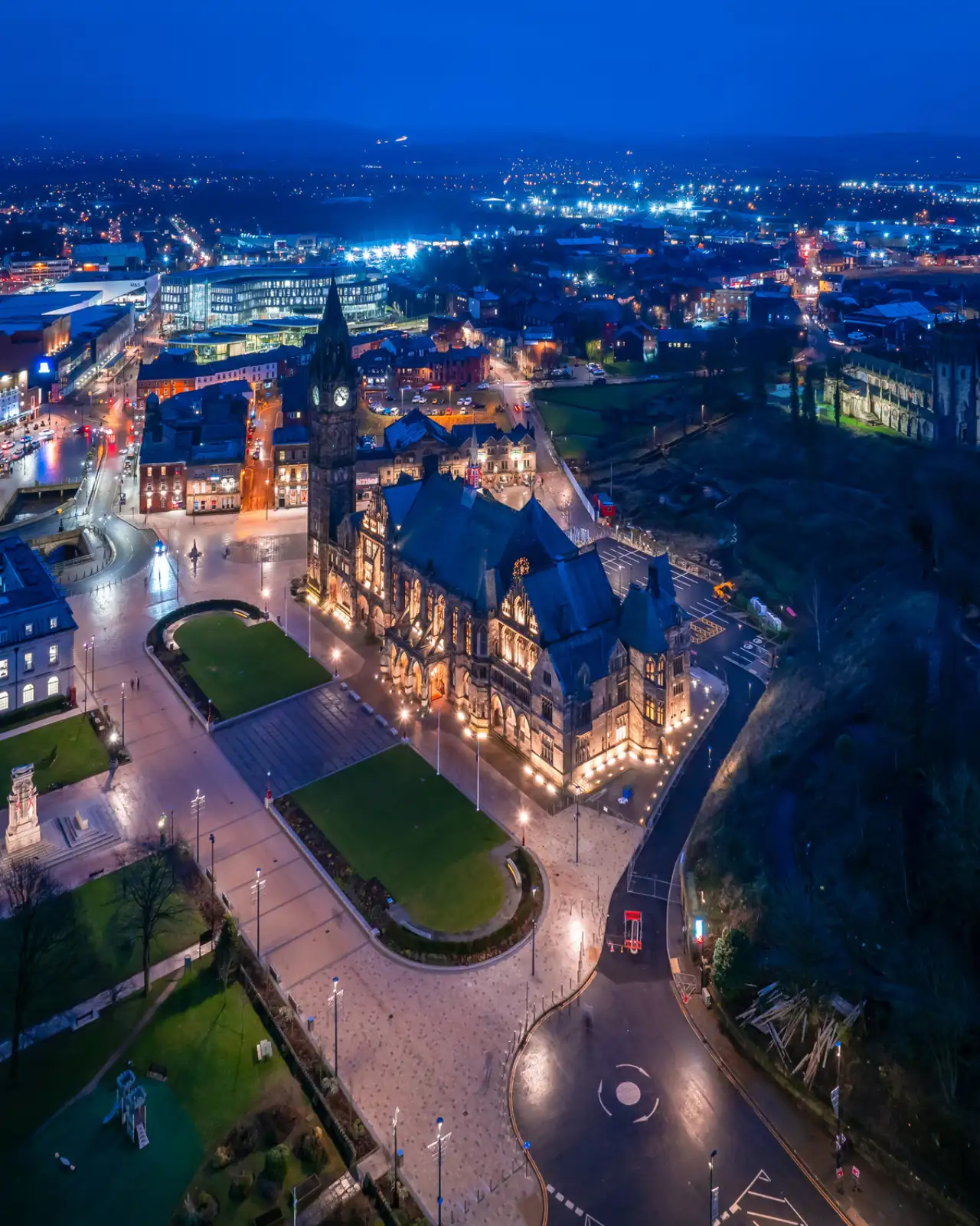 A aerial drone shot of Rochdale Town Hall lit up at night