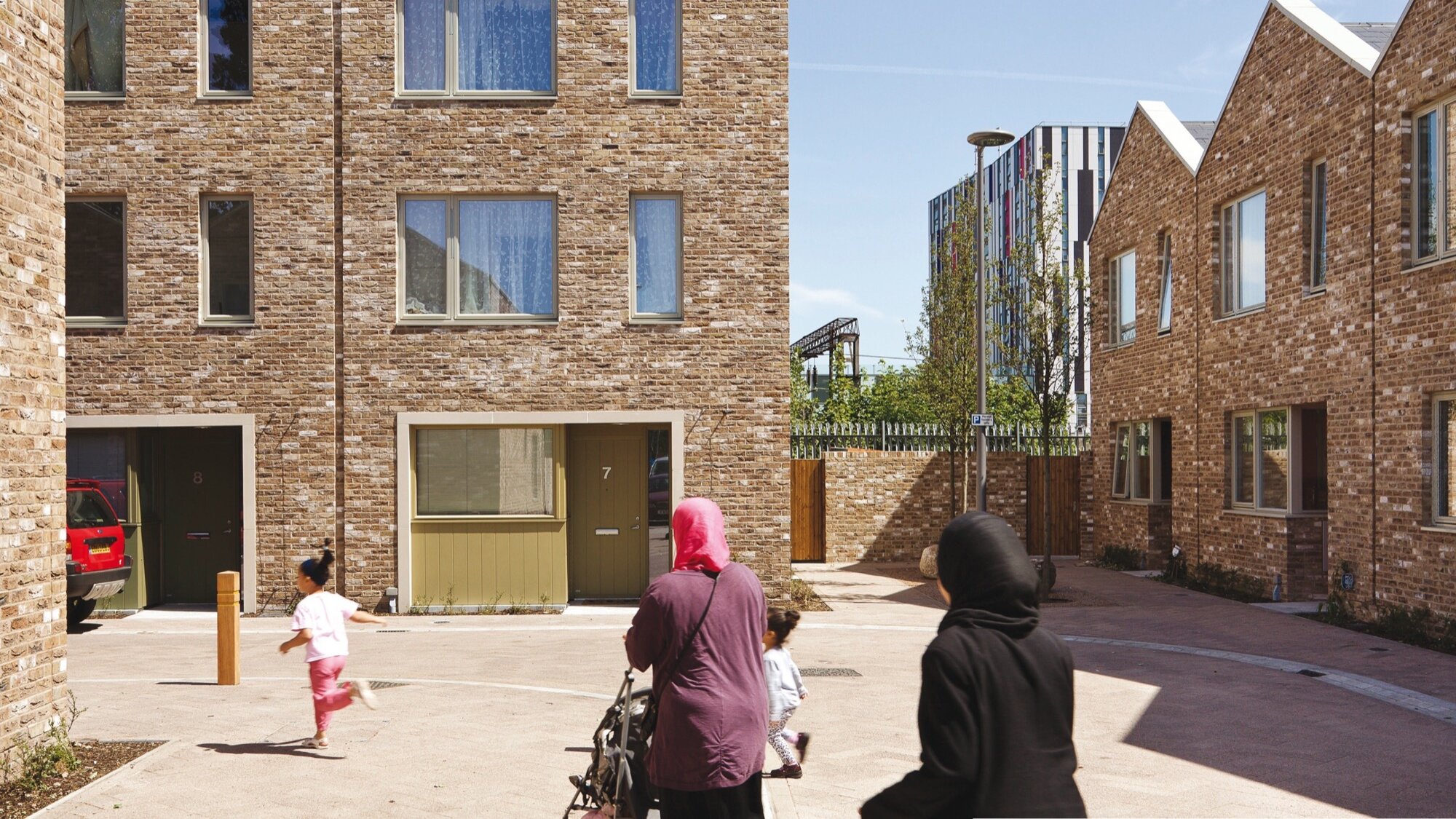 Anne Mews shared surface street with brick housing, family-friendly landscape design, and inclusive urban public realm in Barking.