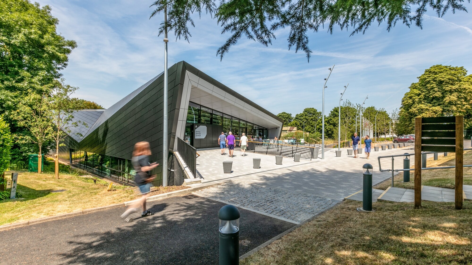 A gently contoured landscape frames the Battle of Britain Visitor Centre, creating a respectful and tranquil setting that responds to its historic context.