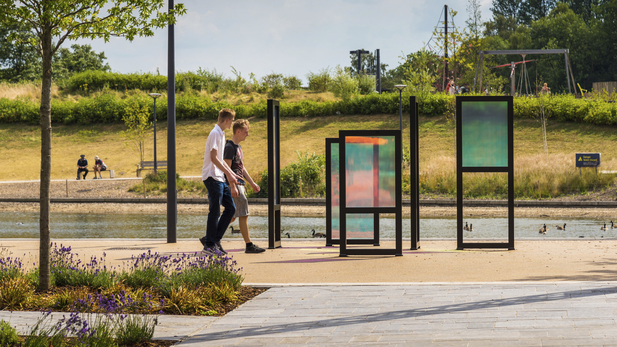 Contemporary landscape architecture at Southwater One with playful signage elements, native planting, pathways, and waterfront public realm design.
