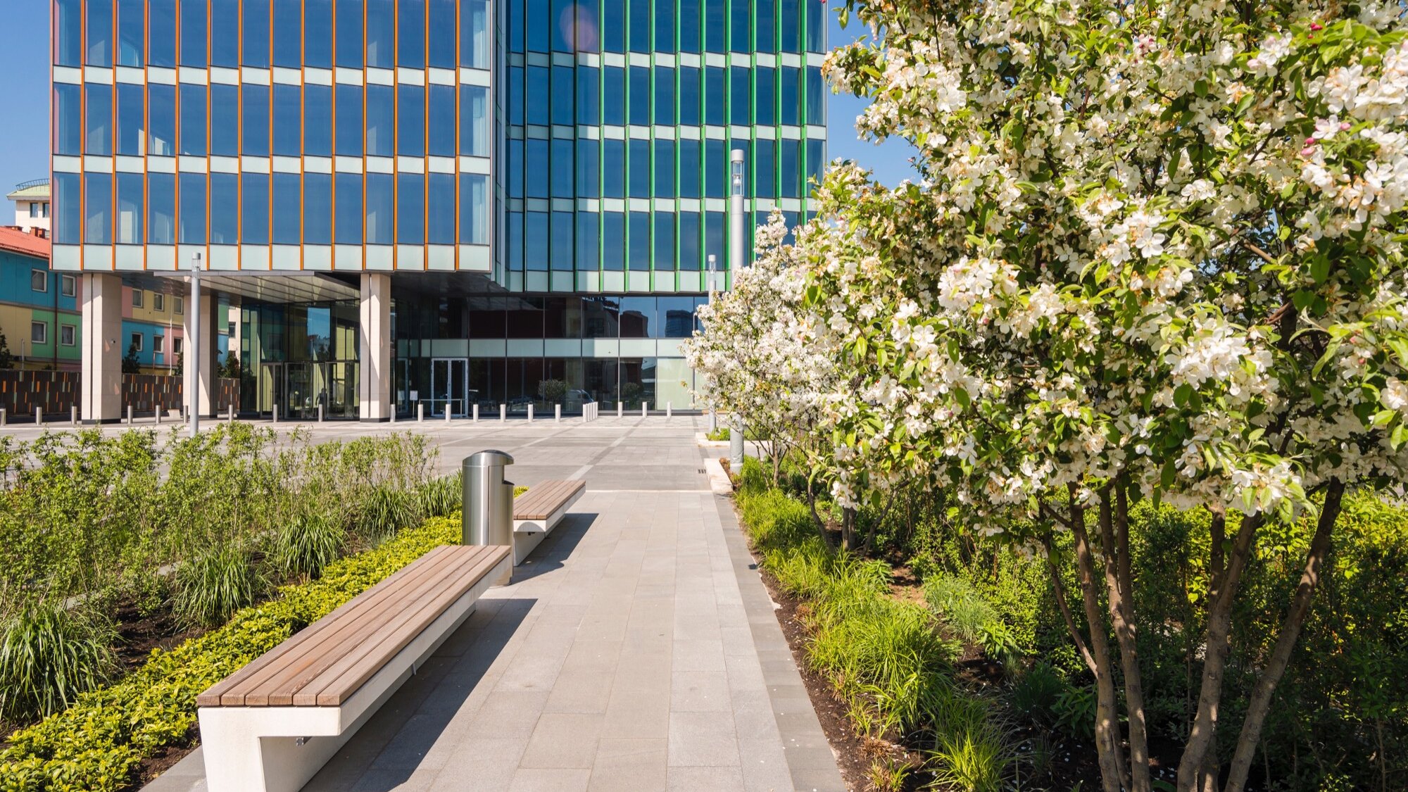 Urban landscape architecture with seating, flowering trees, and planting at Arcus III office development, Leningradsky Prospect, Moscow.