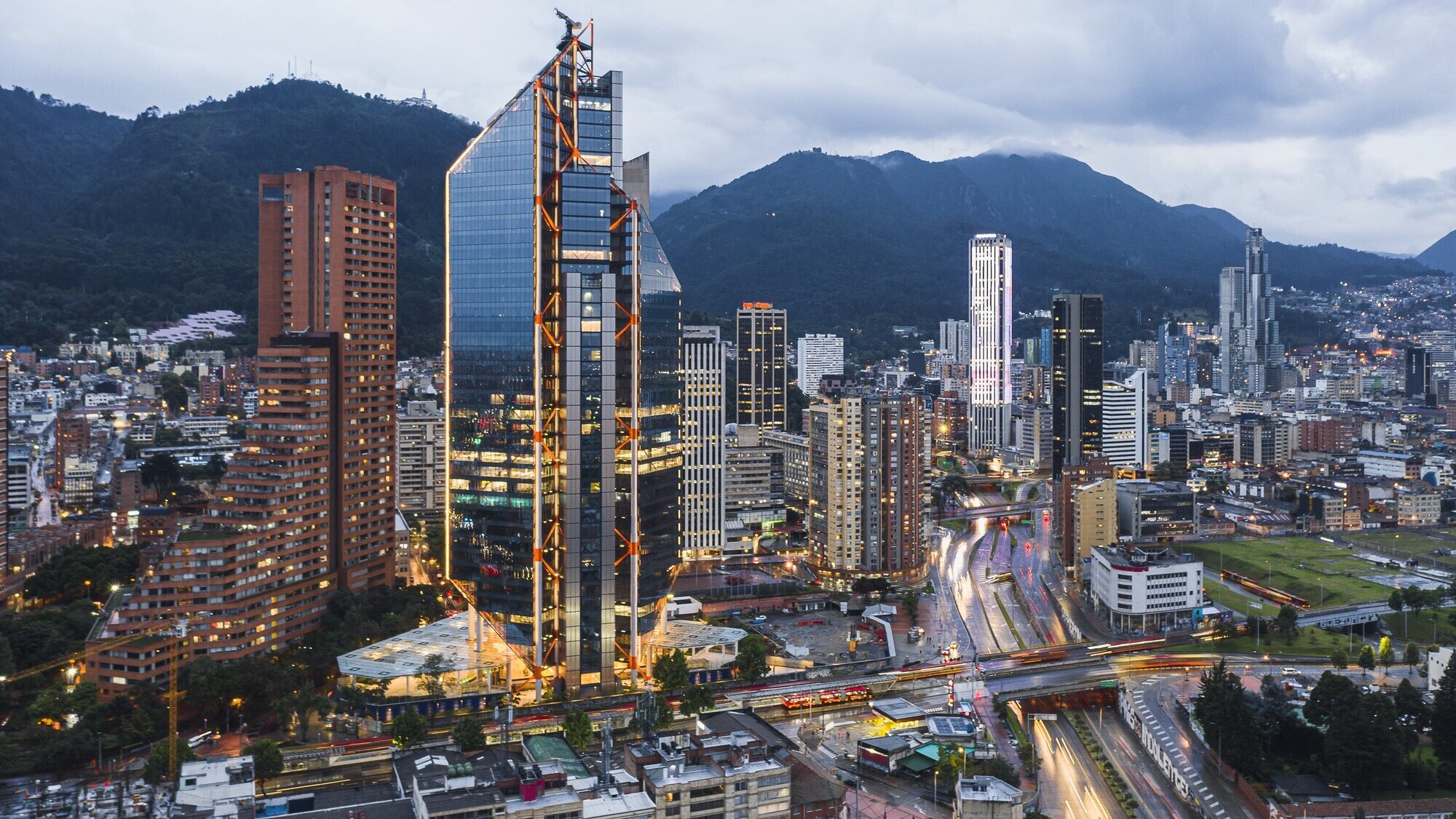Aerial view of ATRIO Bogotá with public realm integration, urban landscape design, and mountain backdrop in city skyline.