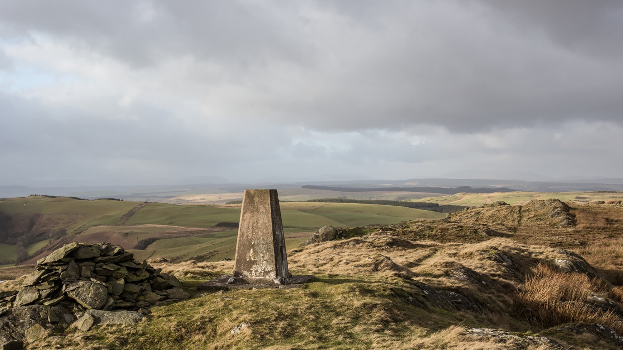 View across rolling upland landscape in Mid Wales with trig point and cairn, part of landscape planning for energy infrastructure studies.