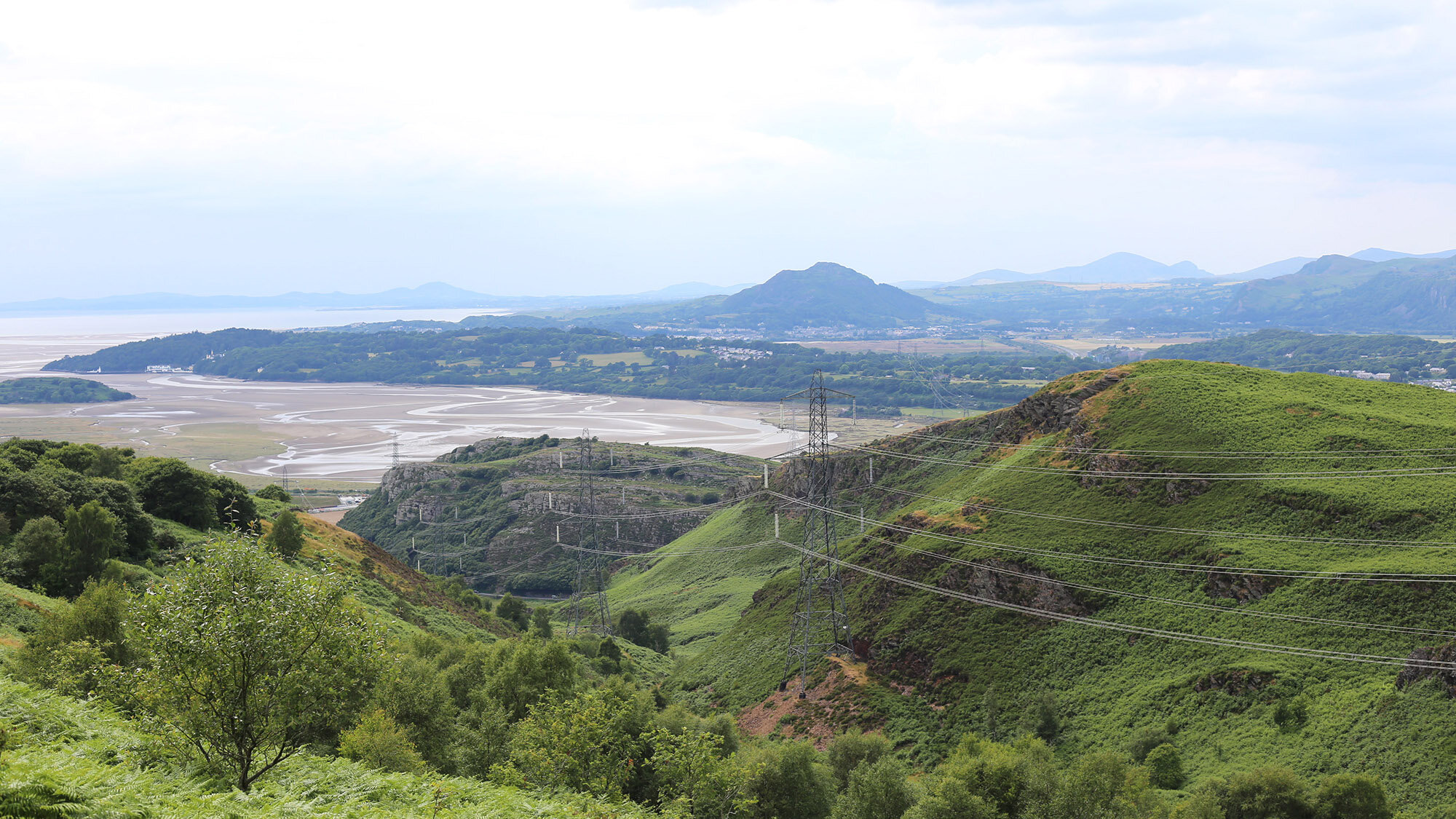 Landscape architecture in protected uplands reducing visual impact of overhead power lines through strategic siting and ecological integration.