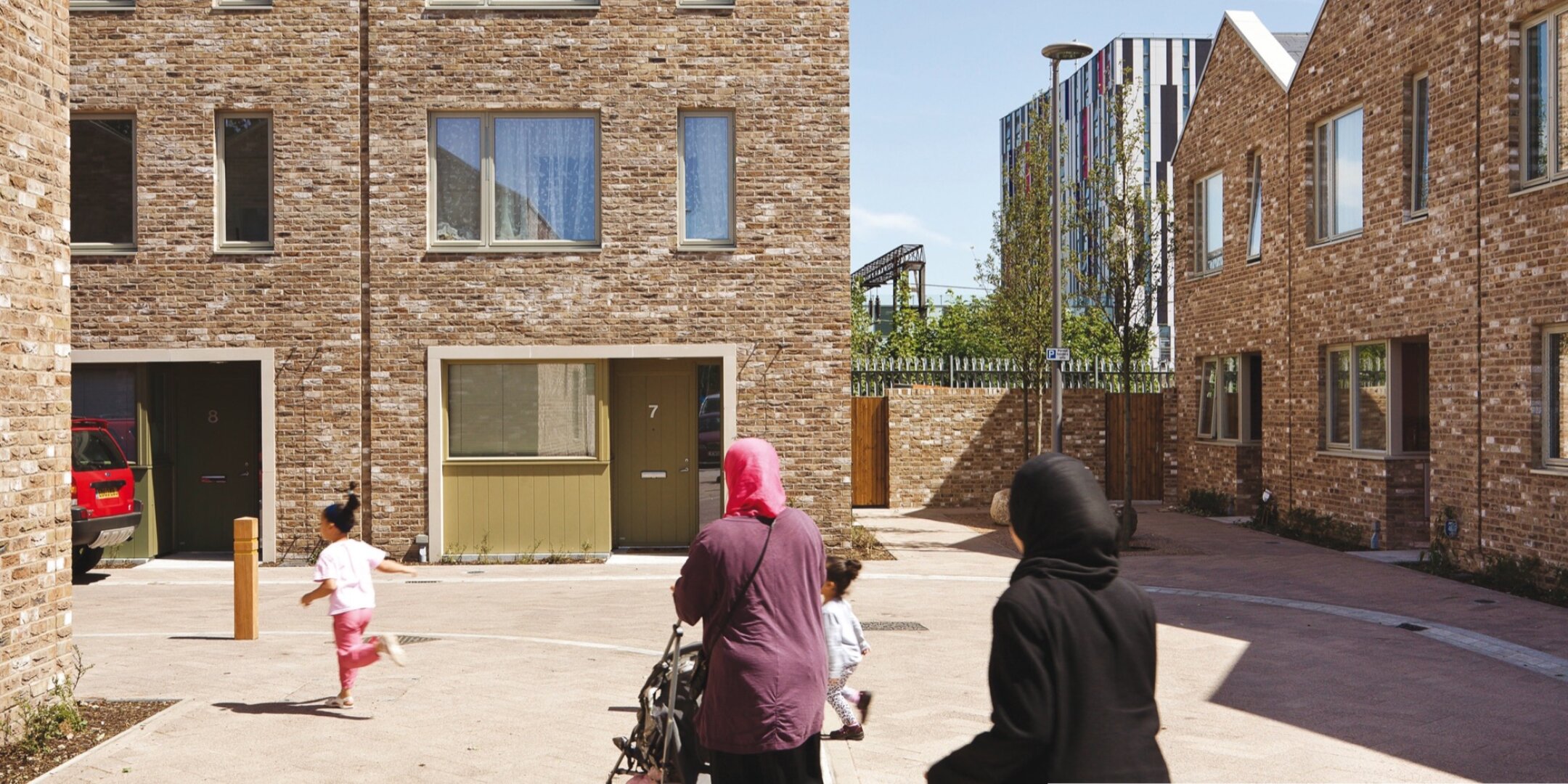 Anne Mews shared surface street with brick housing, family-friendly landscape design, and inclusive urban public realm in Barking.