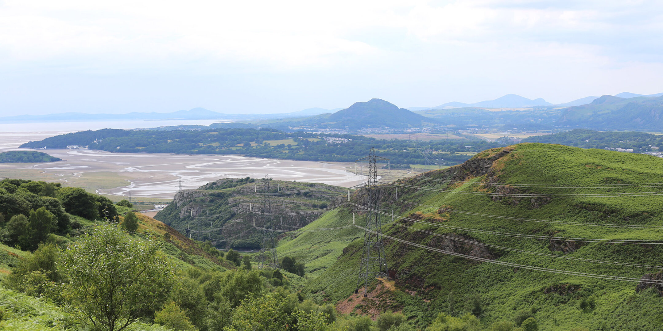 Landscape architecture in protected uplands reducing visual impact of overhead power lines through strategic siting and ecological integration.