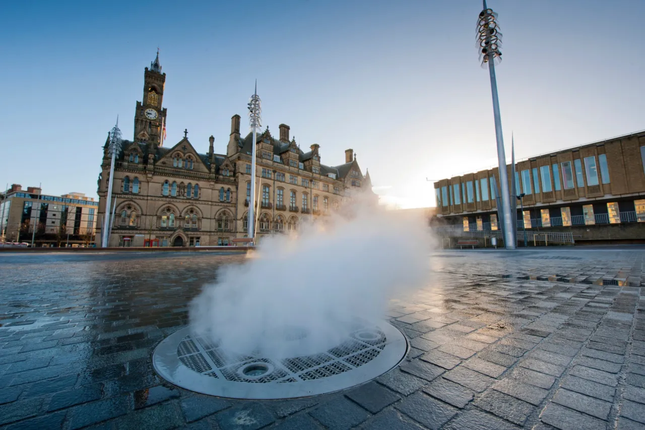 Bradford City Park. Modern urban fountain and public square design by Gillespies. Featuring steam jets, paving, and civic architecture.