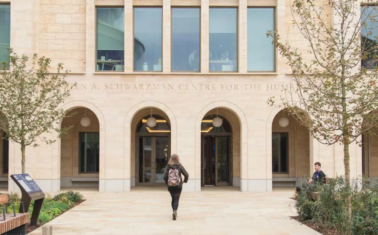 Exterior of the Schwarzman Centre for the Humanities at the University of Oxford with arched entrances and students.