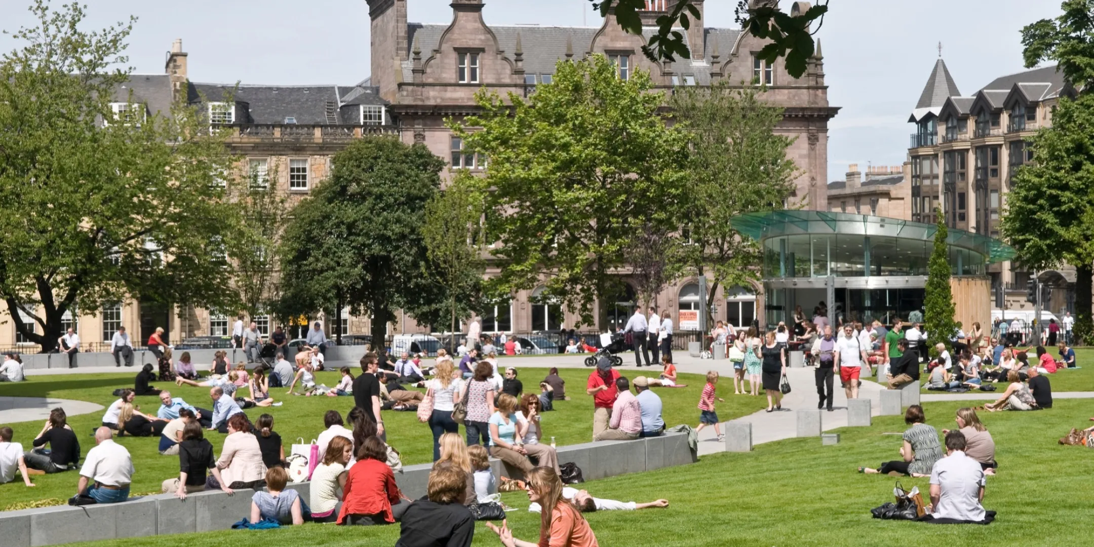 St Andrew Square in central Edinburgh with formal lawn, seating, and vibrant public space designed for social urban use.