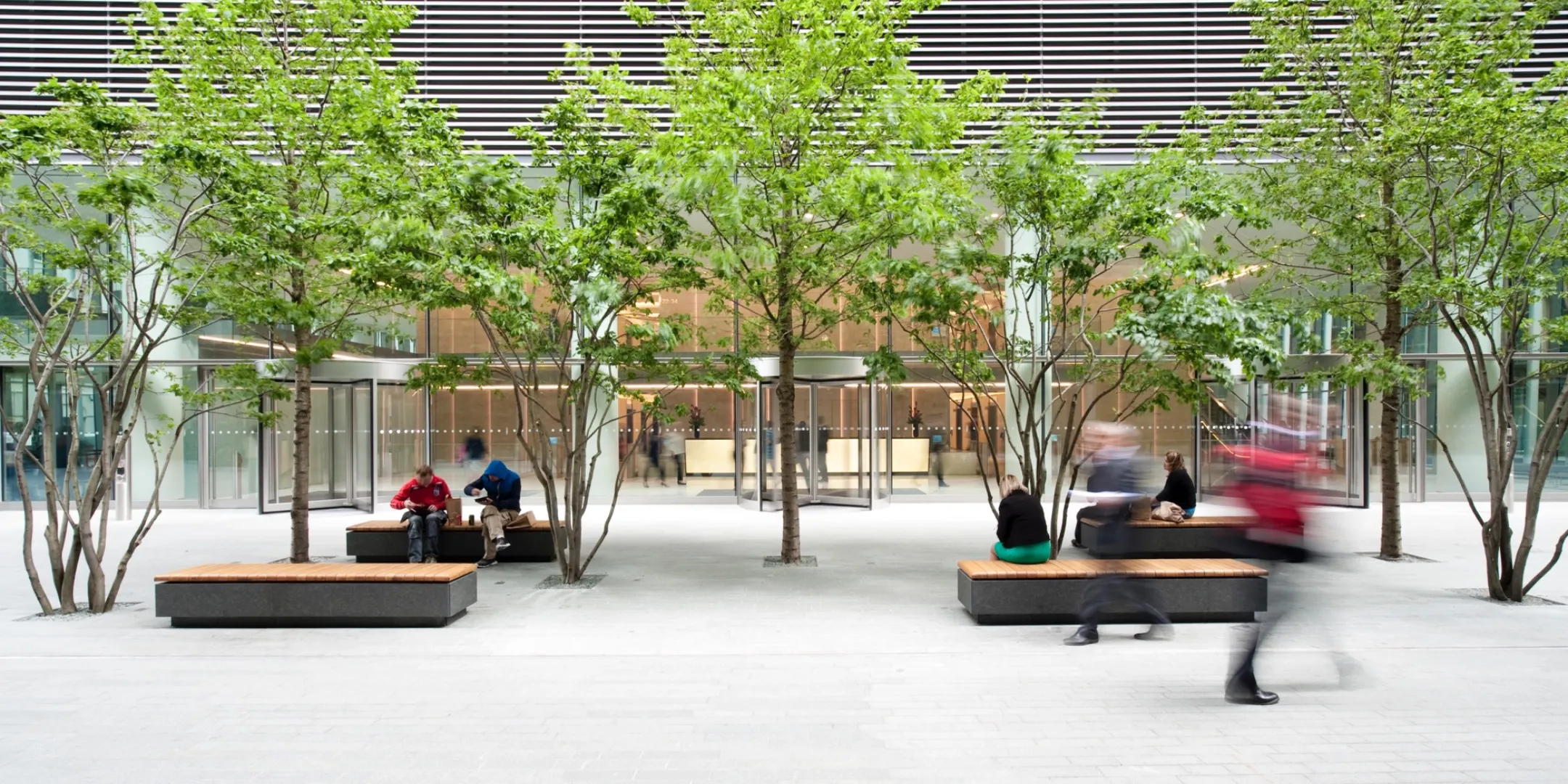 Contemporary urban courtyard with integrated seating, structured tree planting, and minimalist landscape architecture for public space and entrance to 20 Fenchurch Street.