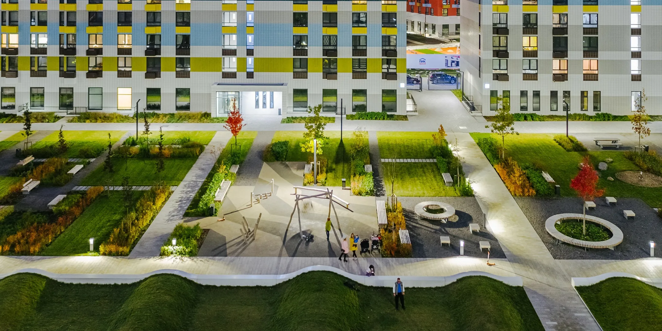 Night view of Varshavskoe Shosse courtyard landscape with playgrounds, planting, and LED lighting in residential Moscow development.