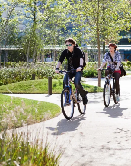 Cyclists on landscaped path at MediaCityUK showcasing active travel integration and sustainable urban design.