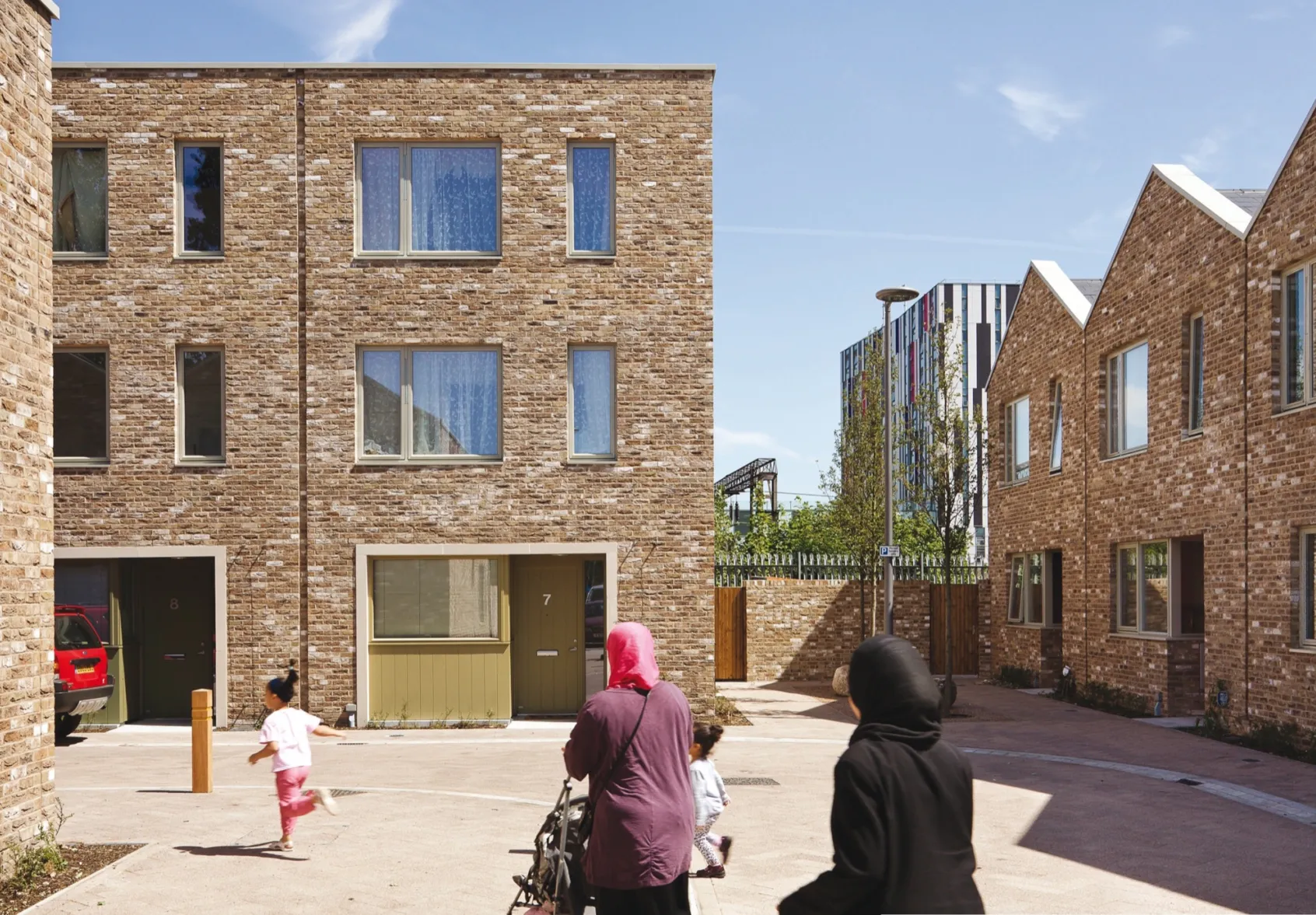Anne Mews shared surface street with brick housing, family-friendly landscape design, and inclusive urban public realm in Barking.