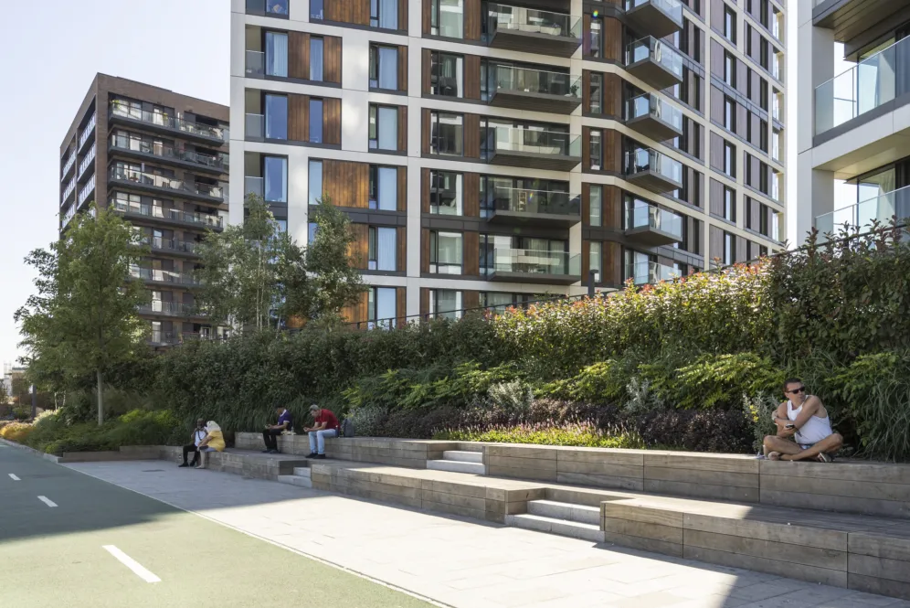 Terraced seating with greenery beside modern apartments at Royal Arsenal Riverside waterfront landscape design.