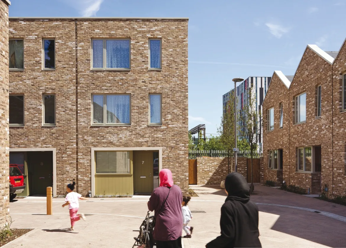 Anne Mews shared surface street with brick housing, family-friendly landscape design, and inclusive urban public realm in Barking.
