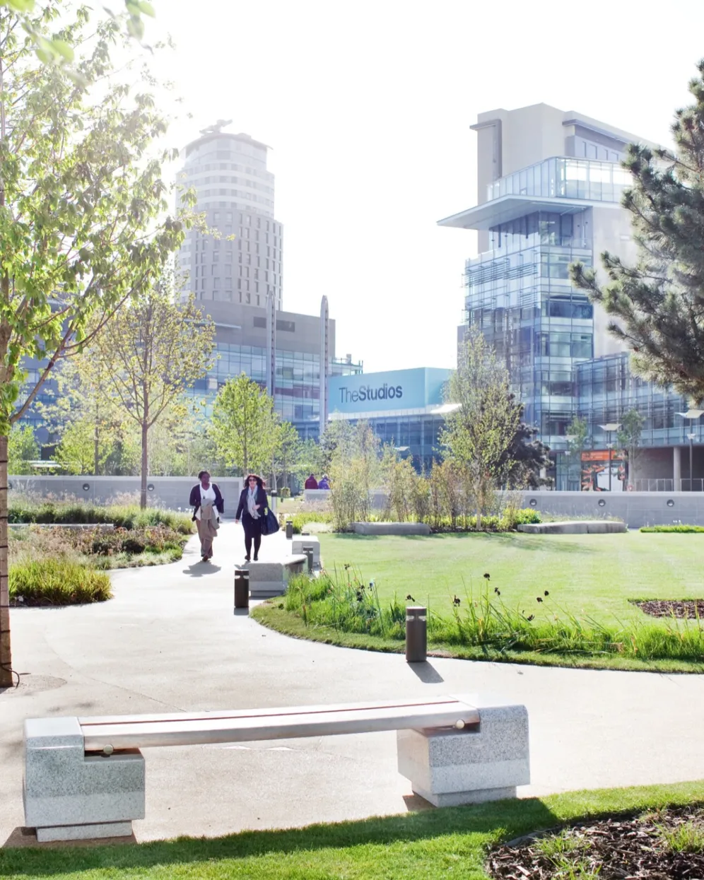 Green infrastructure and urban park design at MediaCityUK featuring curved pathways, seating, and sustainable planting schemes.