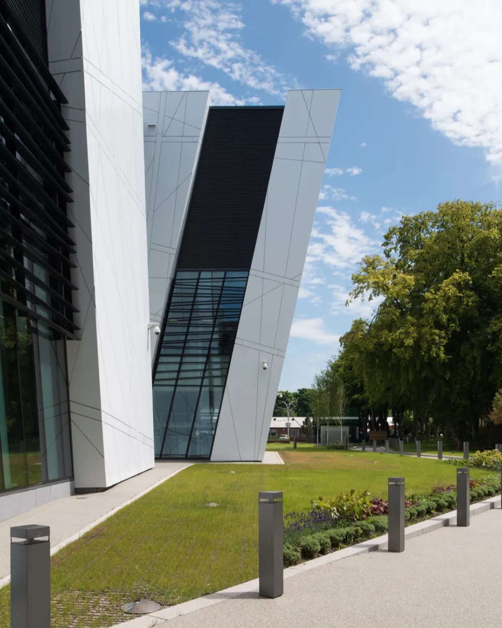 Contemporary landscape architecture at Manchester Cancer Research Centre featuring green space, tree planting, and accessible pedestrian paths.