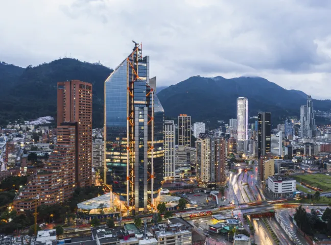 Aerial view of ATRIO Bogotá with public realm integration, urban landscape design, and mountain backdrop in city skyline.