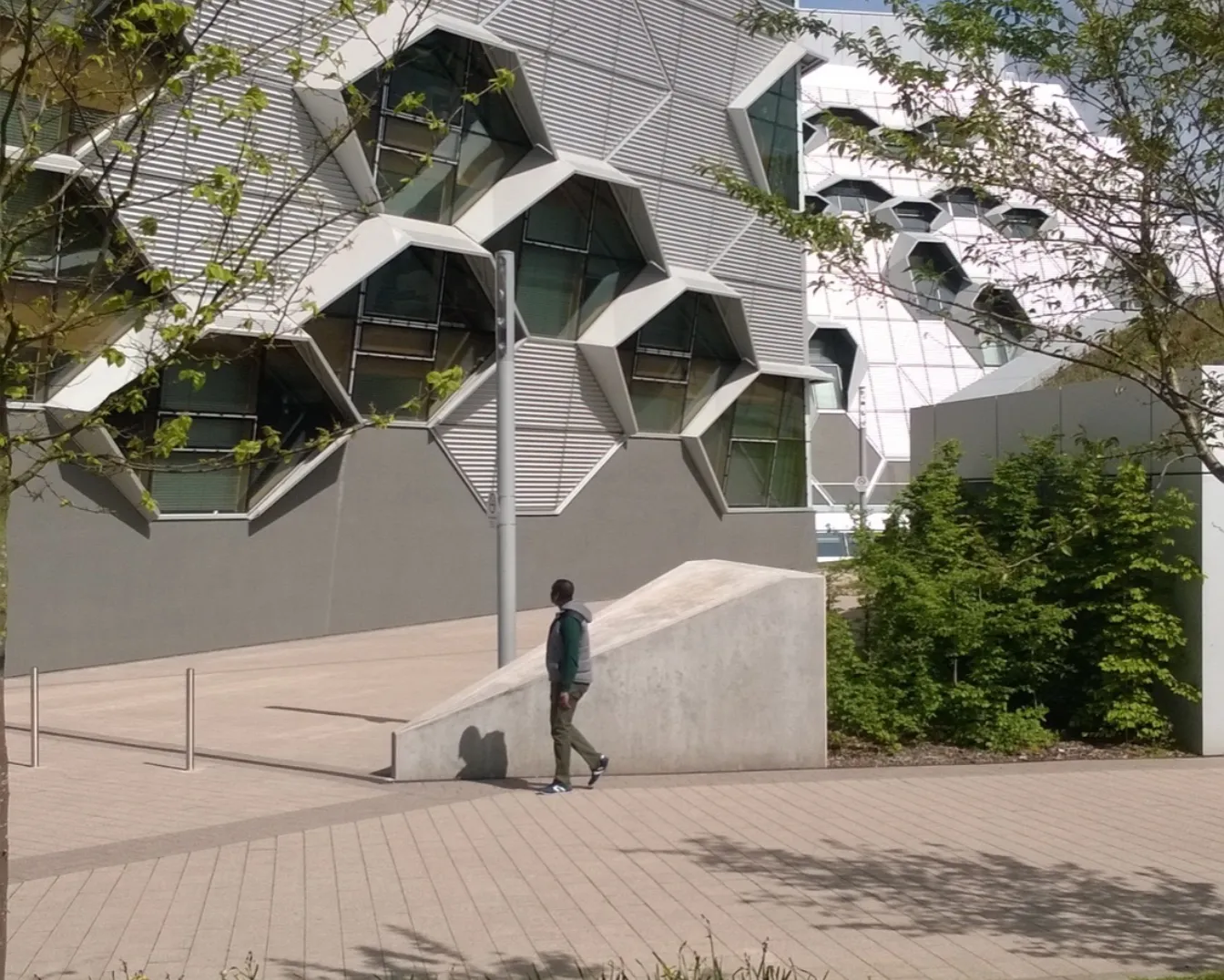 Coventry University modern architecture with geometric facade, landscaped green spaces, and pedestrian-friendly campus design.