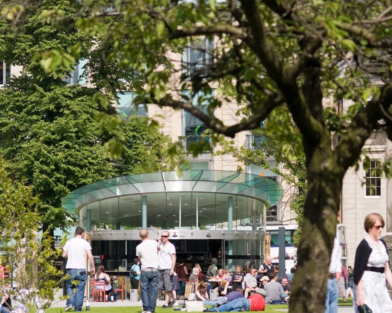 St Andrew Square landscape design with lawn, trees, and café pavilion promoting urban relaxation in Edinburgh city centre.