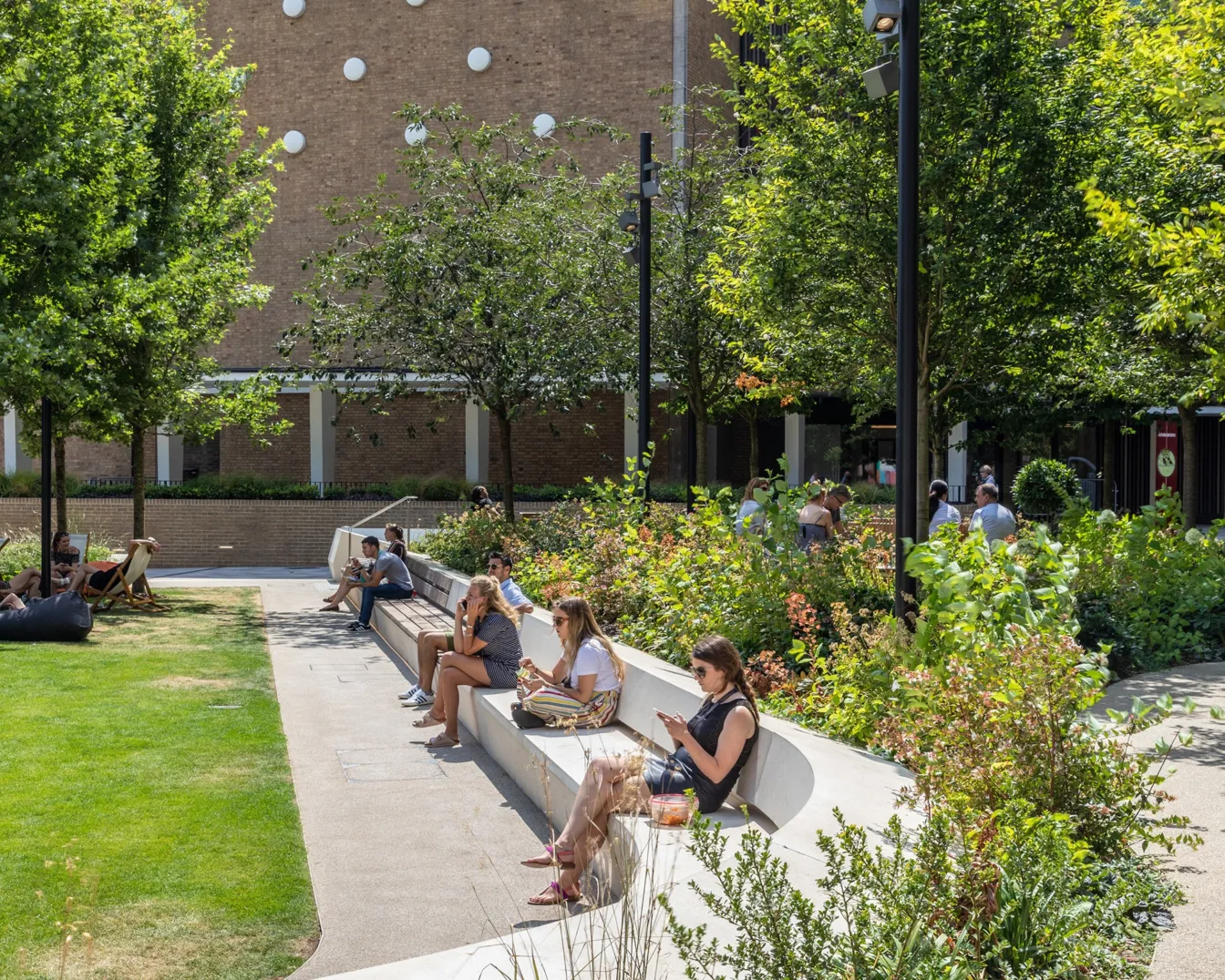 Television Centre landscape design with curved seating, planting beds, trees, and public green space for relaxation.