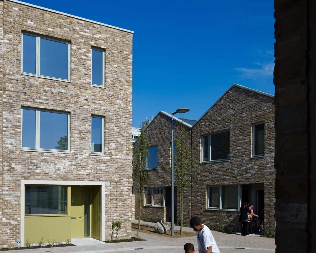 Anne Mews Barking features family-friendly shared courtyards, brick housing, street trees, and inclusive urban landscape design.