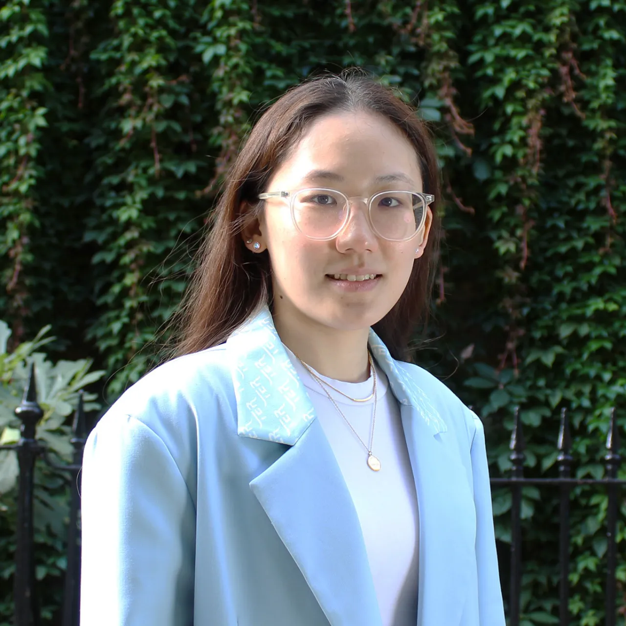 Mian Han, a young Graduate Landscape Architect in Gillespies' London studio, standing in a green setting