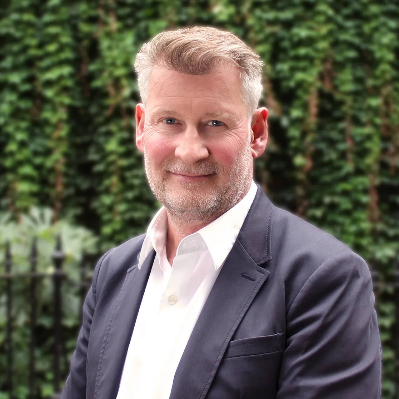 Jim Diggle, Managing Partner of Gillespies, standing in front of a greenwall in London.