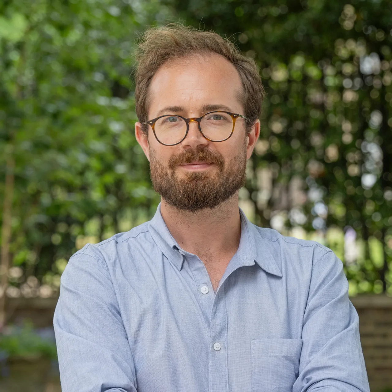 Patrick Conn, Chartered Landscape Architect and Associate at Gillespies, smiling in an urban space in London.