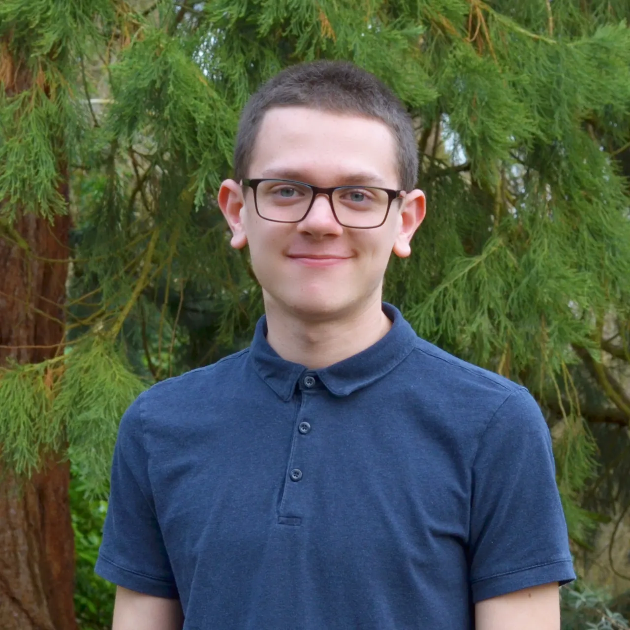 Sam Brinkworth, a young Trainee Finance Assistant in Gillespies' Oxford studio, smiling in a woodland setting