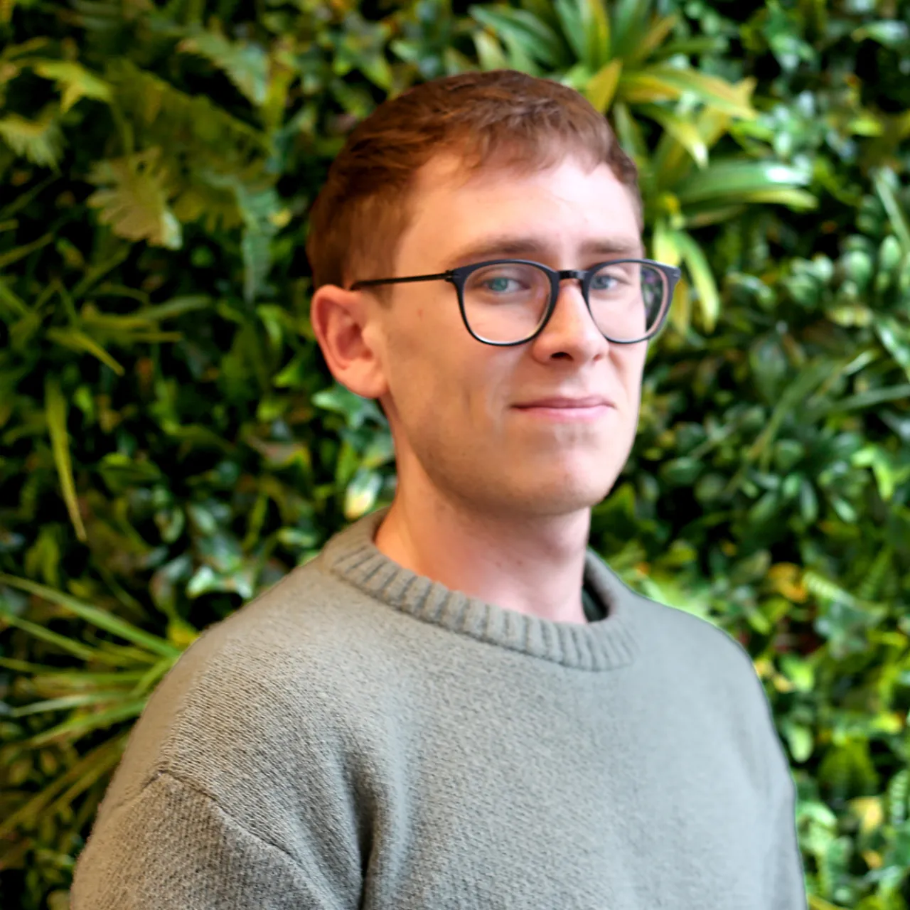 Fraser, a young Assistant Landscape Architect at Gillespies' Manchester studio, standing in front of a greenwall