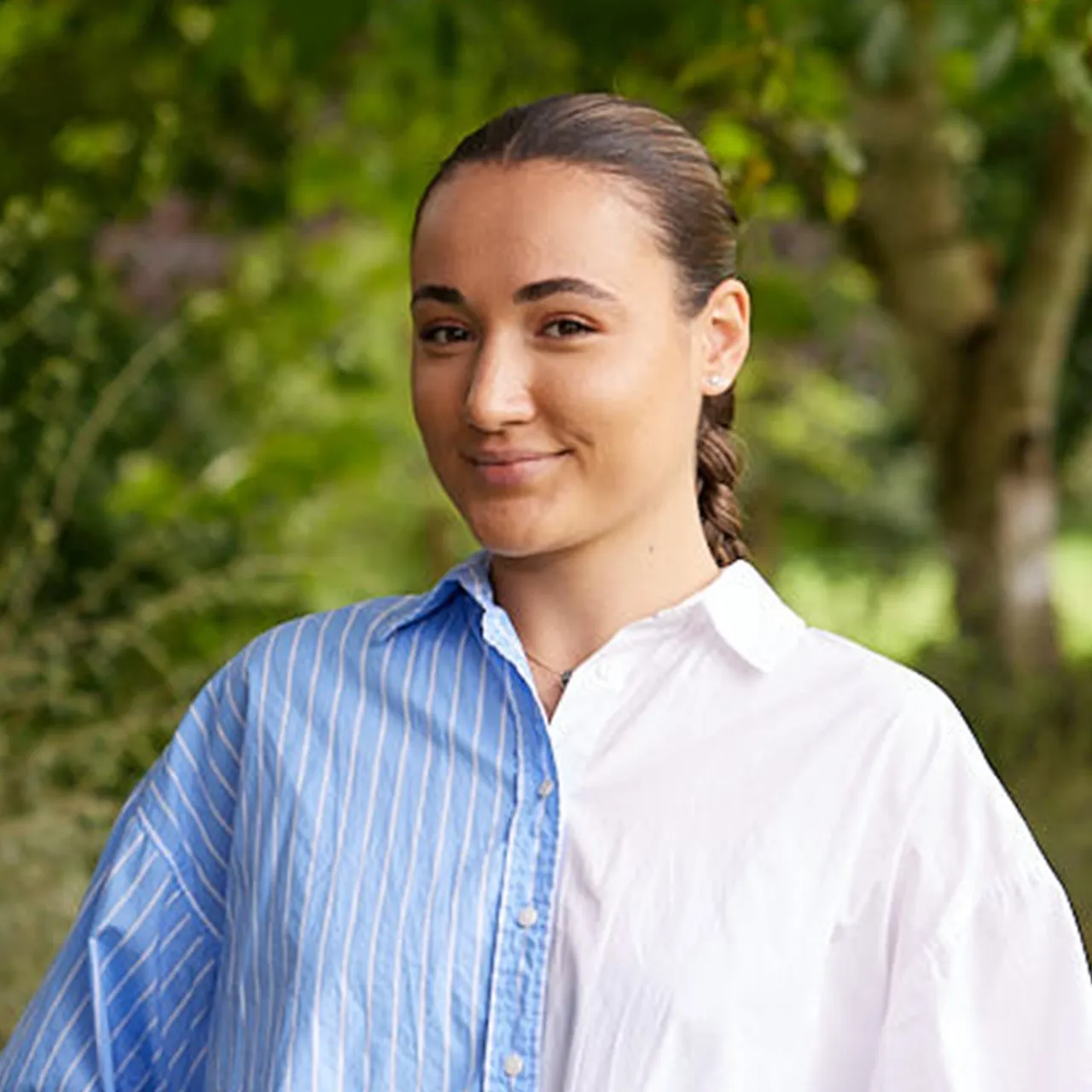 Andreea Moanta, Graduate Landscape Architect, standing in front of a leafy background in Manchester