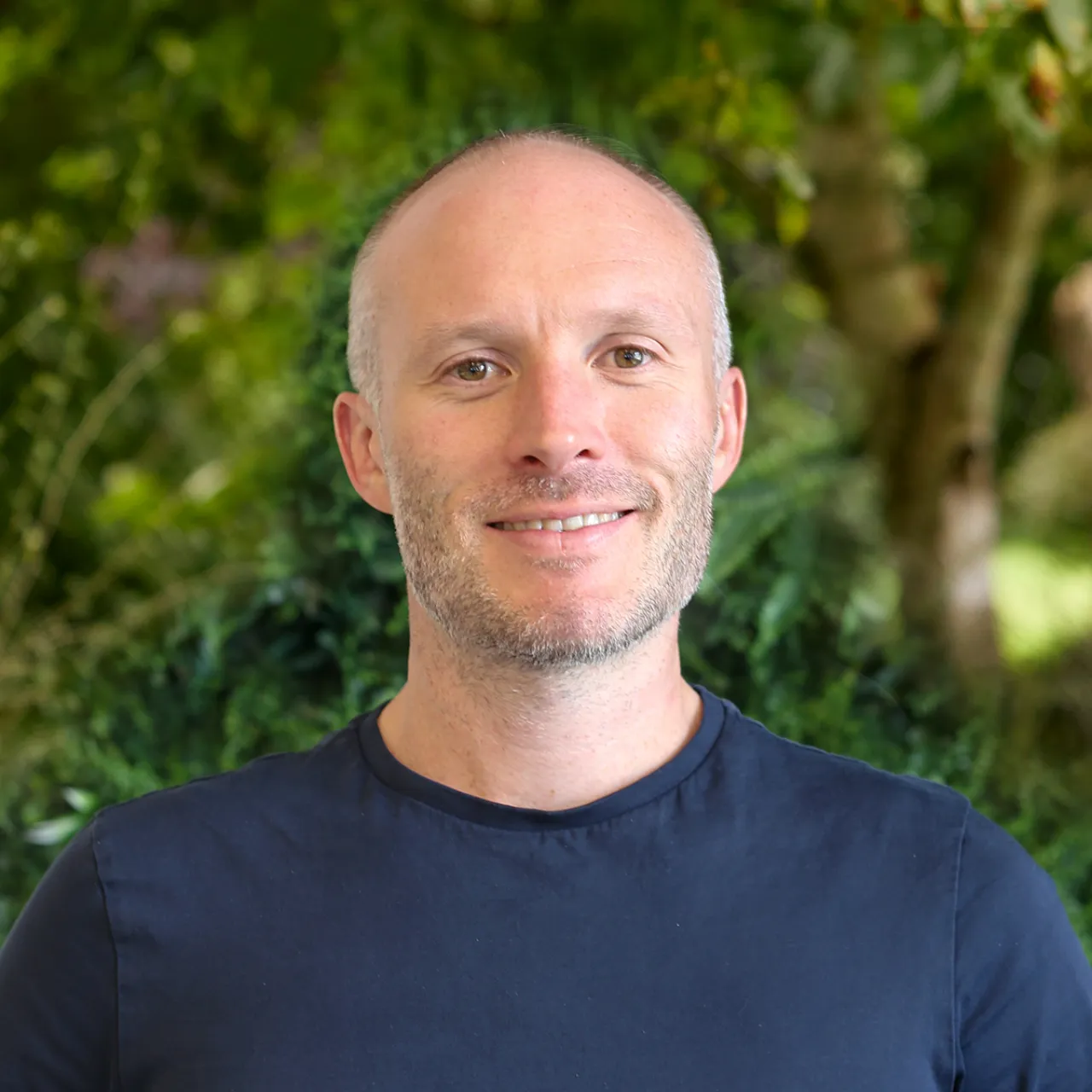 Charlie Griffin, landscape planner in Manchester, smiling in front of a green landscape