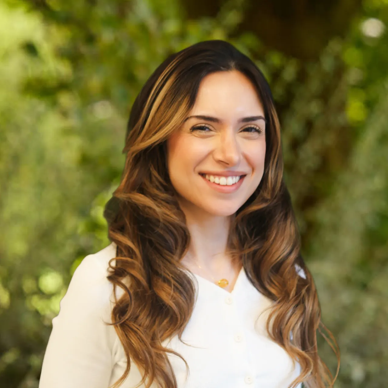 Architect Lena Karim smiling in front of a leafy background