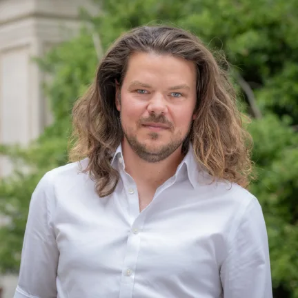Headshot of Associate Partner Oliver Duguid in an urban setting